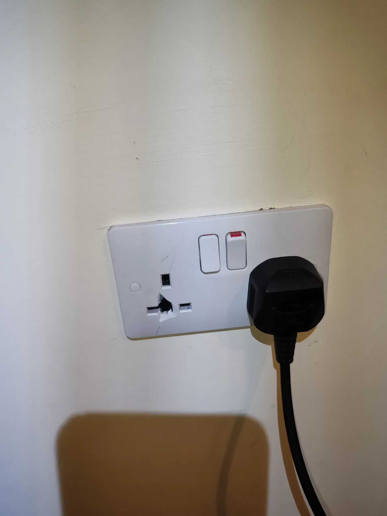 Cracked 13A socket outlet with exposed live pins inside broken faceplate — C2 finding during homebuyer EICR in Leicester