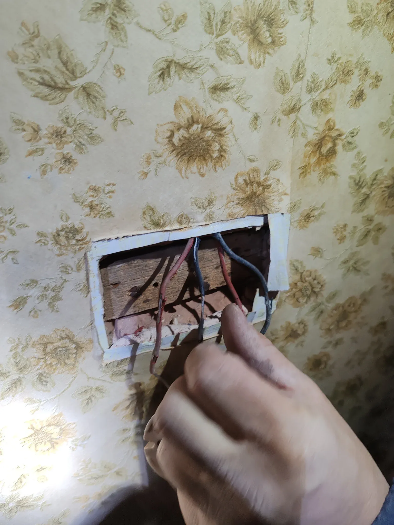 Original red and black rubber-insulated wiring exposed during strip-out on a pre-1960s Leicester property — clear case for full rewire