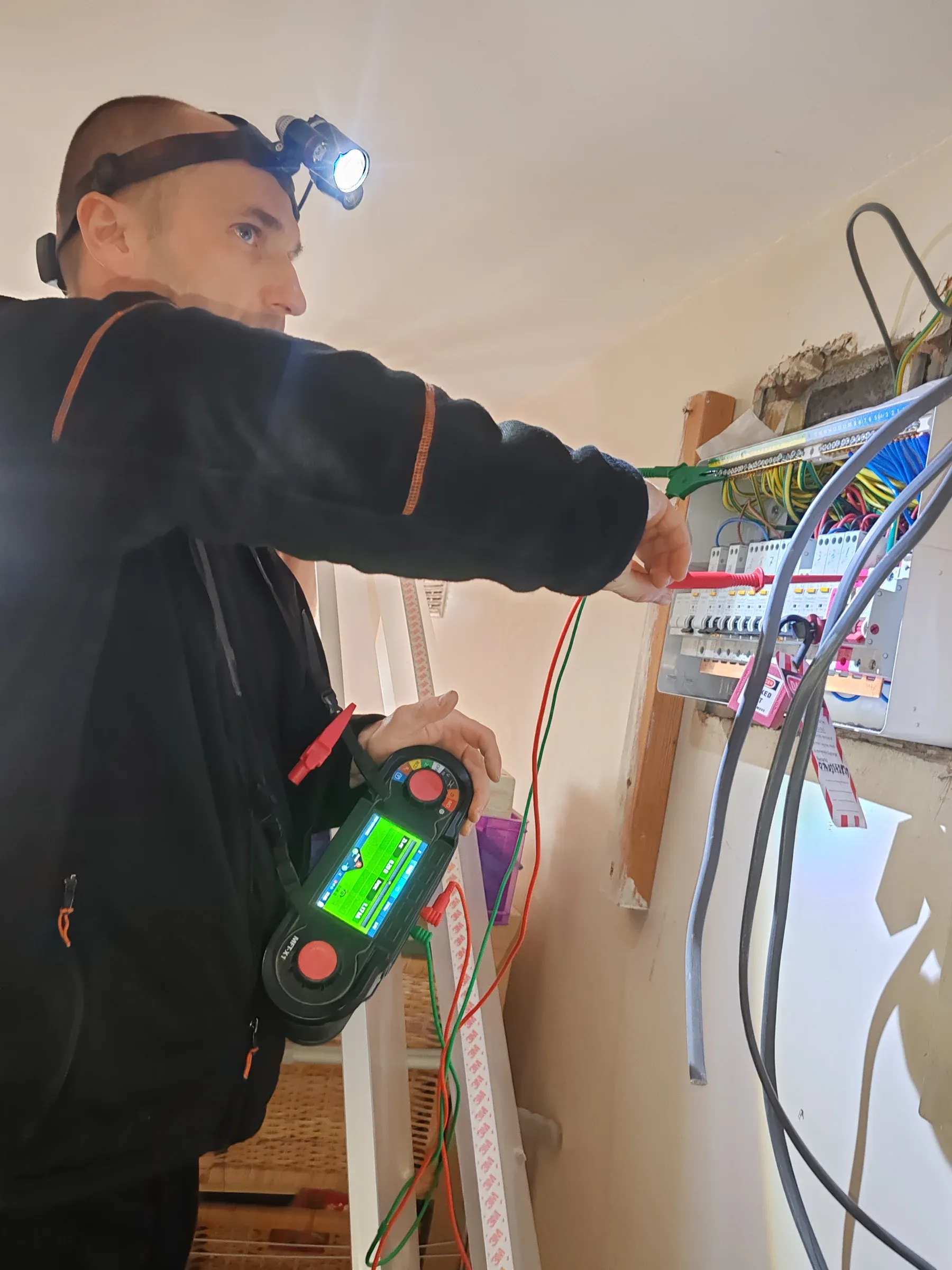 Electrician testing a new consumer unit during a house rewire using a multifunction tester