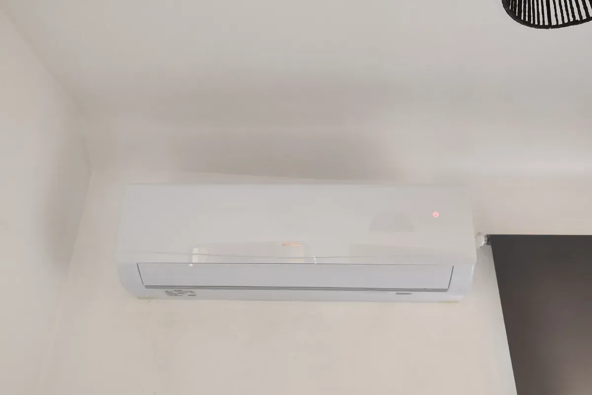 Wall mounted air conditioning indoor unit installed high on a bedroom wall